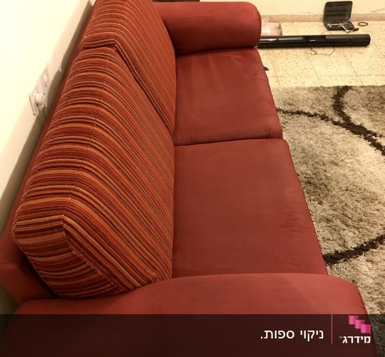 ספה אדומה עם כריות פסים, שטיח על הרצפה